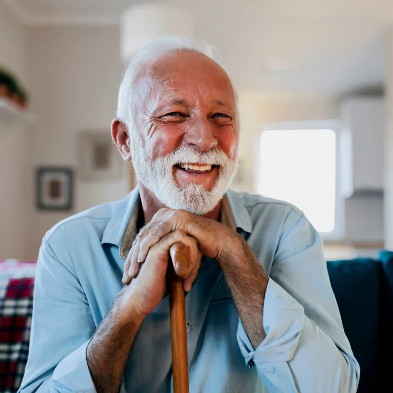 Man with cane smiling at camera