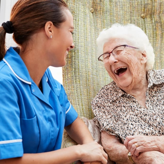 senior woman with nurse laughing